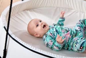 Baby ligger i en Sort Sansegynge med et hvidt telt