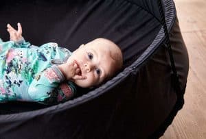 Baby ligger i en Sort Sansegynge med en sort kant