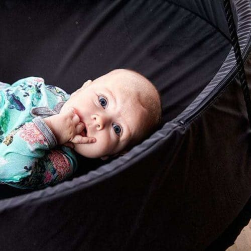 Baby ligger i en Sort Sansegynge med en sort kant